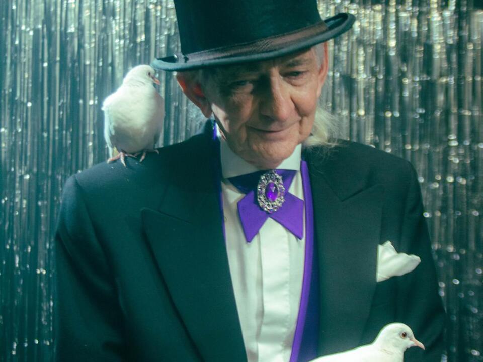 Pat Fallon performing a dove illusion in formal costume